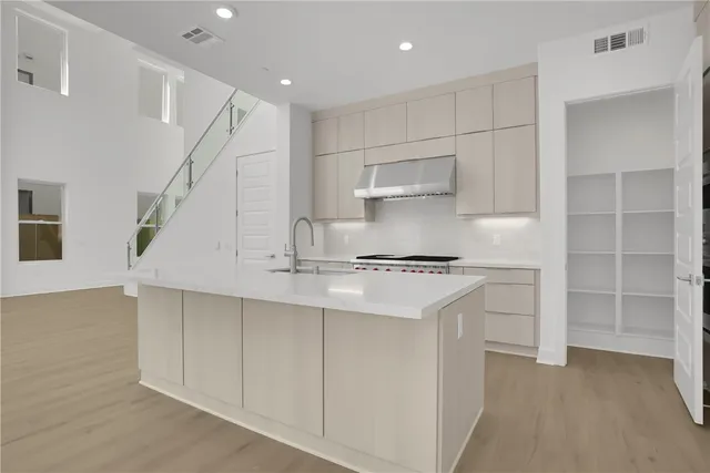 a kitchen with kitchen island a sink stainless steel appliances and cabinets