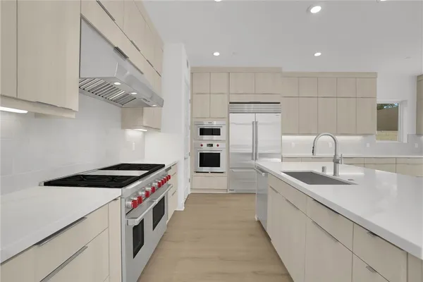 a kitchen with stainless steel appliances granite countertop a sink and a refrigerator