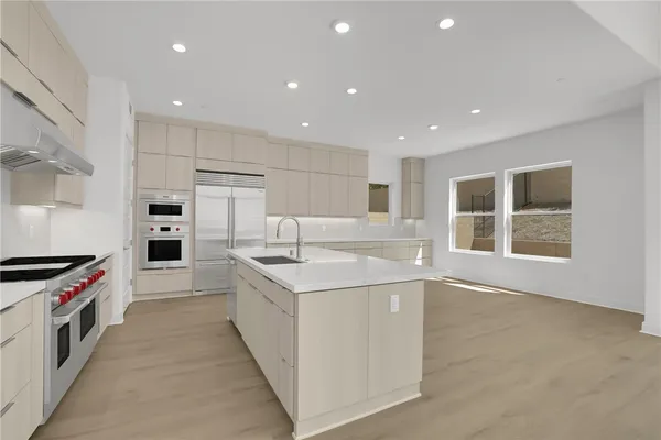 a kitchen with white cabinets appliances and a window