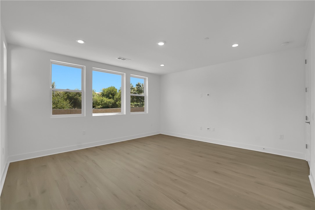168 Creation Irvine, CA 92618 - Photo 26 of 59 an empty room with wooden floor and windows