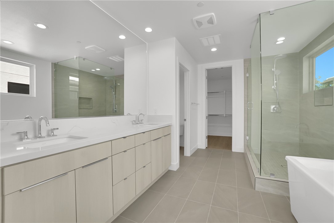 168 Creation Irvine, CA 92618 - Photo 29 of 59 a bathroom with a double vanity sink a toilet and a shower