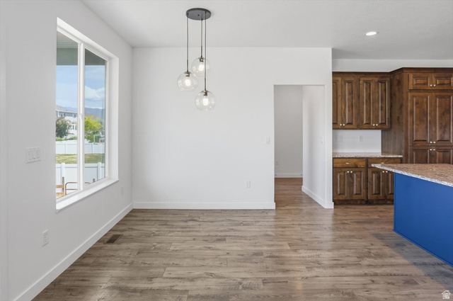3636 West 910 South Syracuse, UT 84075 - Photo 41 of 70 Open-concept area featuring wood-finish flooring, a modern three-light pendant fixture, and a large window