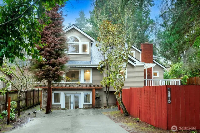 a view of a house with a backyard and tree
