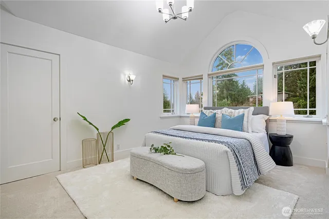 a spacious bedroom with a bed and a painting on the wall