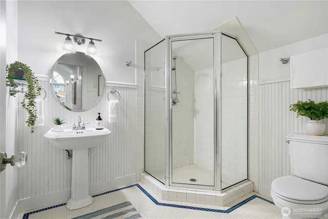 a bathroom with a sink a mirror a toilet and shower