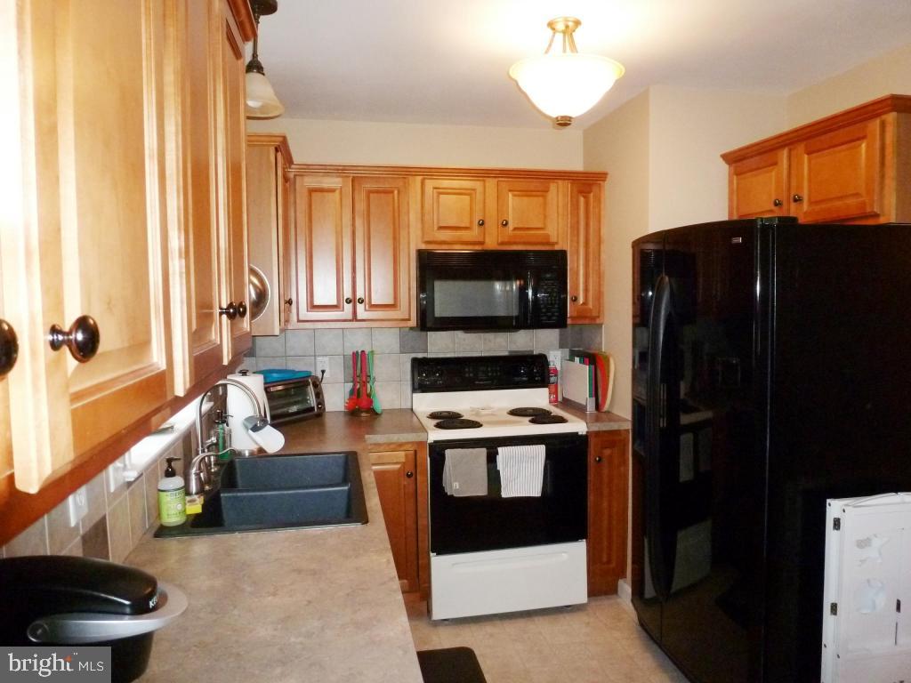 600 Chatham Way Lititz, PA 17543 - Photo 6 of 26 a kitchen with stainless steel appliances a stove a refrigerator and a fireplace