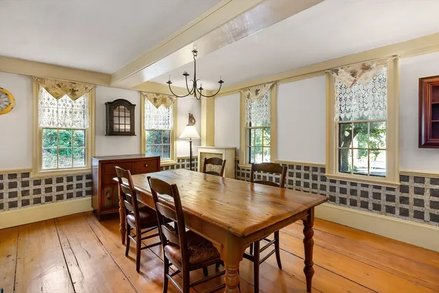 a view of a dining room and livingroom with furniture window and wooden floor