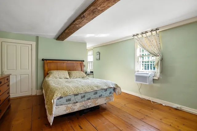 a view of a bedroom with furniture and window