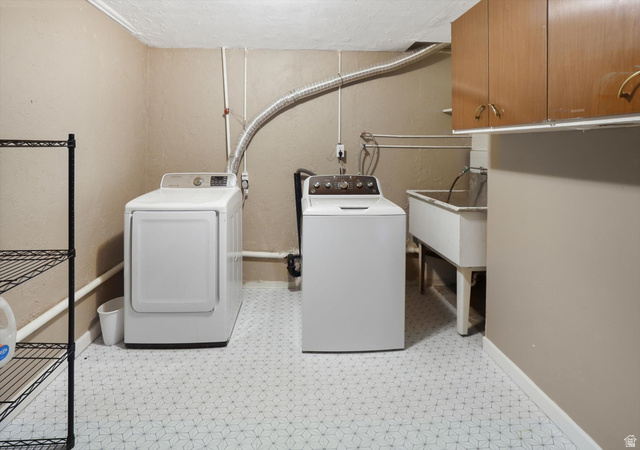5108 South 2000th Street West Roy, UT 84067 - Photo 44 of 61 Laundry area with washer and dryer, light floors, and cabinet space