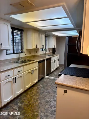 a kitchen with sink cabinets and appliances