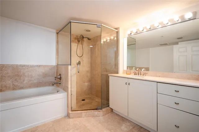 a bathroom with a granite countertop sink mirror bathtub and shower