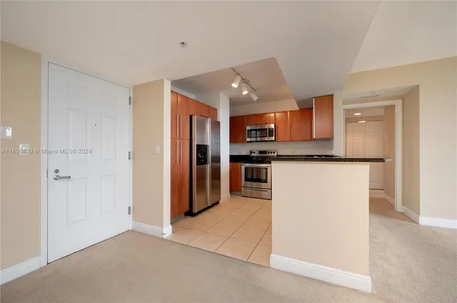 a kitchen with stainless steel appliances granite countertop a refrigerator and a stove top oven