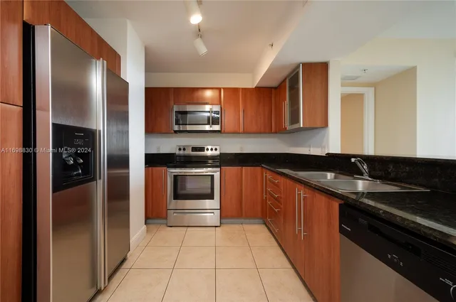a kitchen with stainless steel appliances granite countertop a refrigerator and a sink