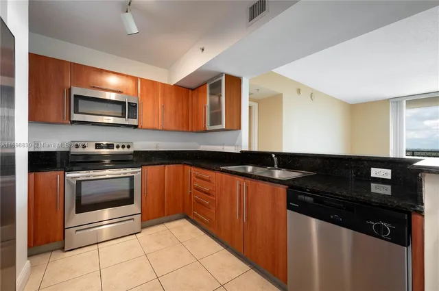 a kitchen with granite countertop a stove and cabinets