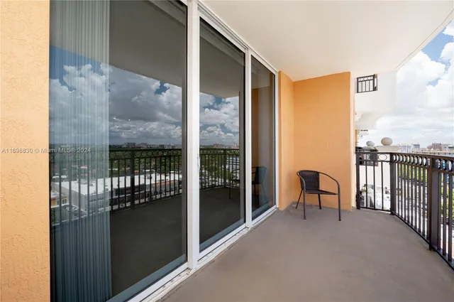 a view of a balcony with furniture and floor to ceiling window