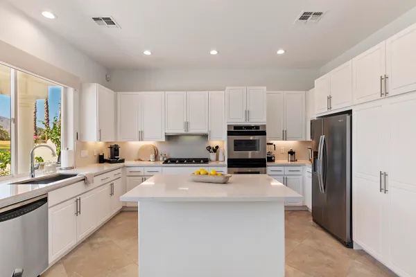 a kitchen with stainless steel appliances a refrigerator sink stove microwave and cabinets