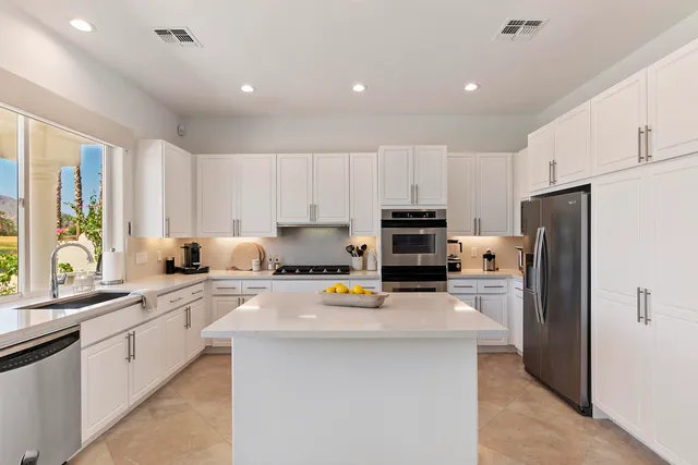 a kitchen with stainless steel appliances a refrigerator sink stove microwave and cabinets