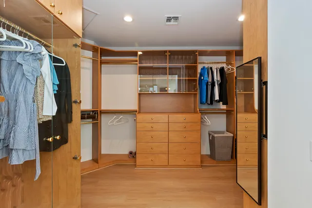 a view of walk in closet with clothes and shoes