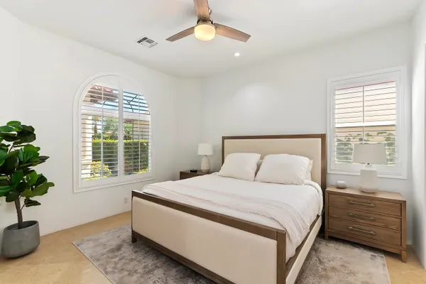 a bedroom with a bed and a potted plant