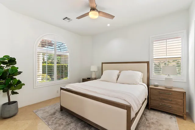 a bedroom with a bed and a potted plant