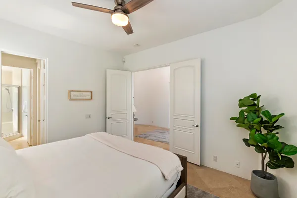 a bedroom with a bed and a potted plant