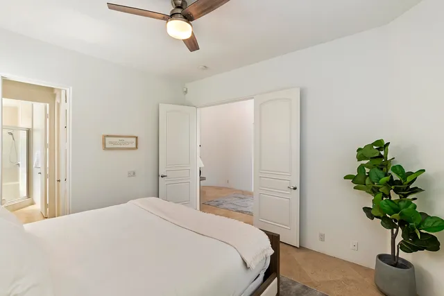 a bedroom with a bed and a potted plant
