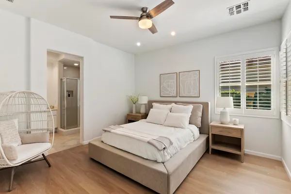 a bedroom with a bed wooden floor and window