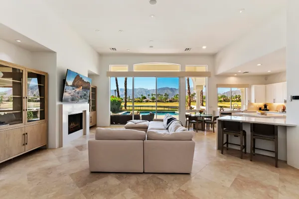 a living room with furniture a fireplace and a large window