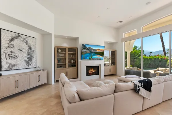 a living room with furniture a fireplace and a large window