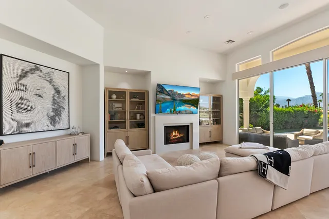 a living room with furniture a fireplace and a large window