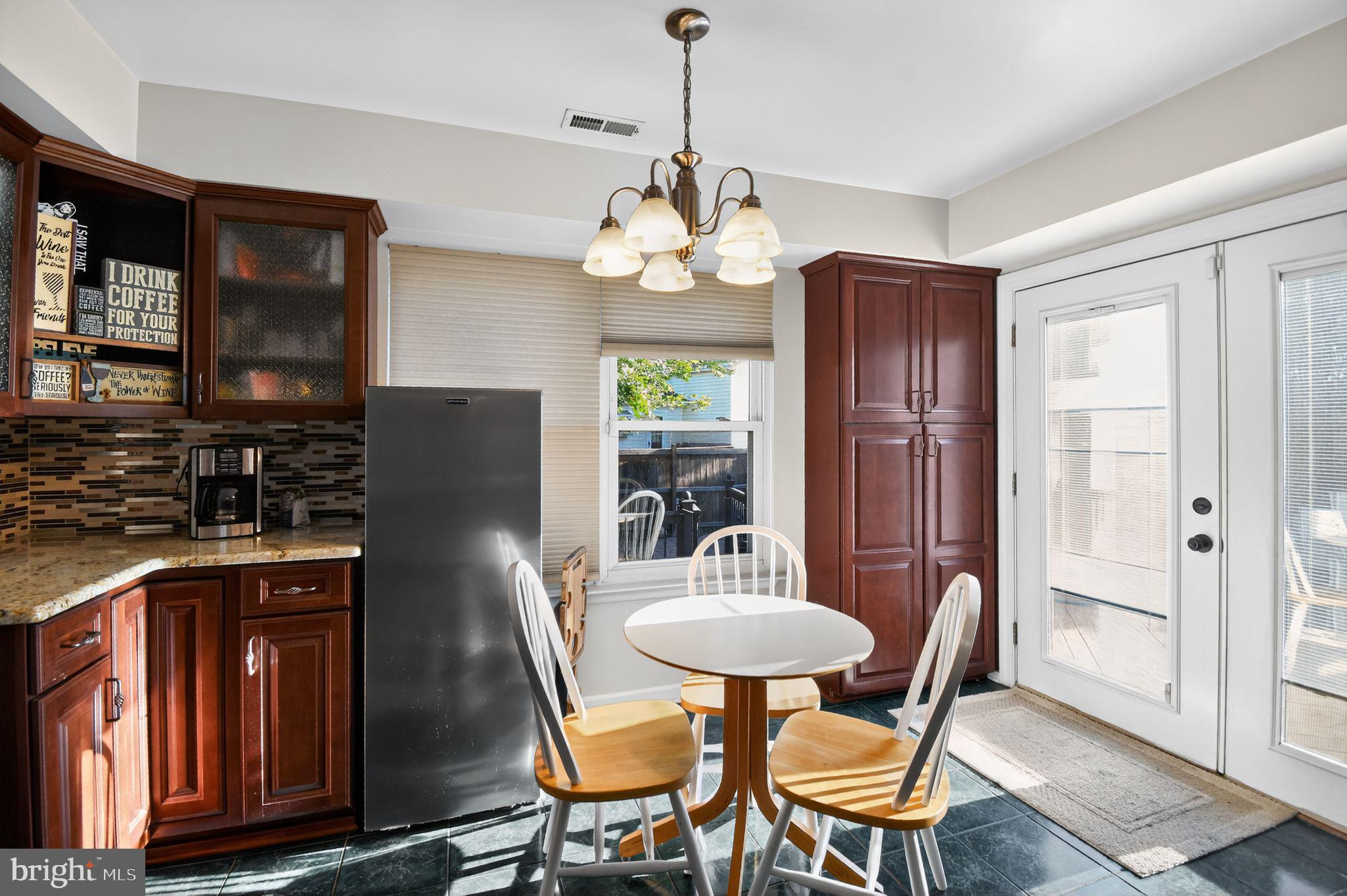 22040 Caravel Court Great Mills, MD 20634 - Photo 19 of 32 a dining room with wooden floor a chandelier a wooden table and chairs