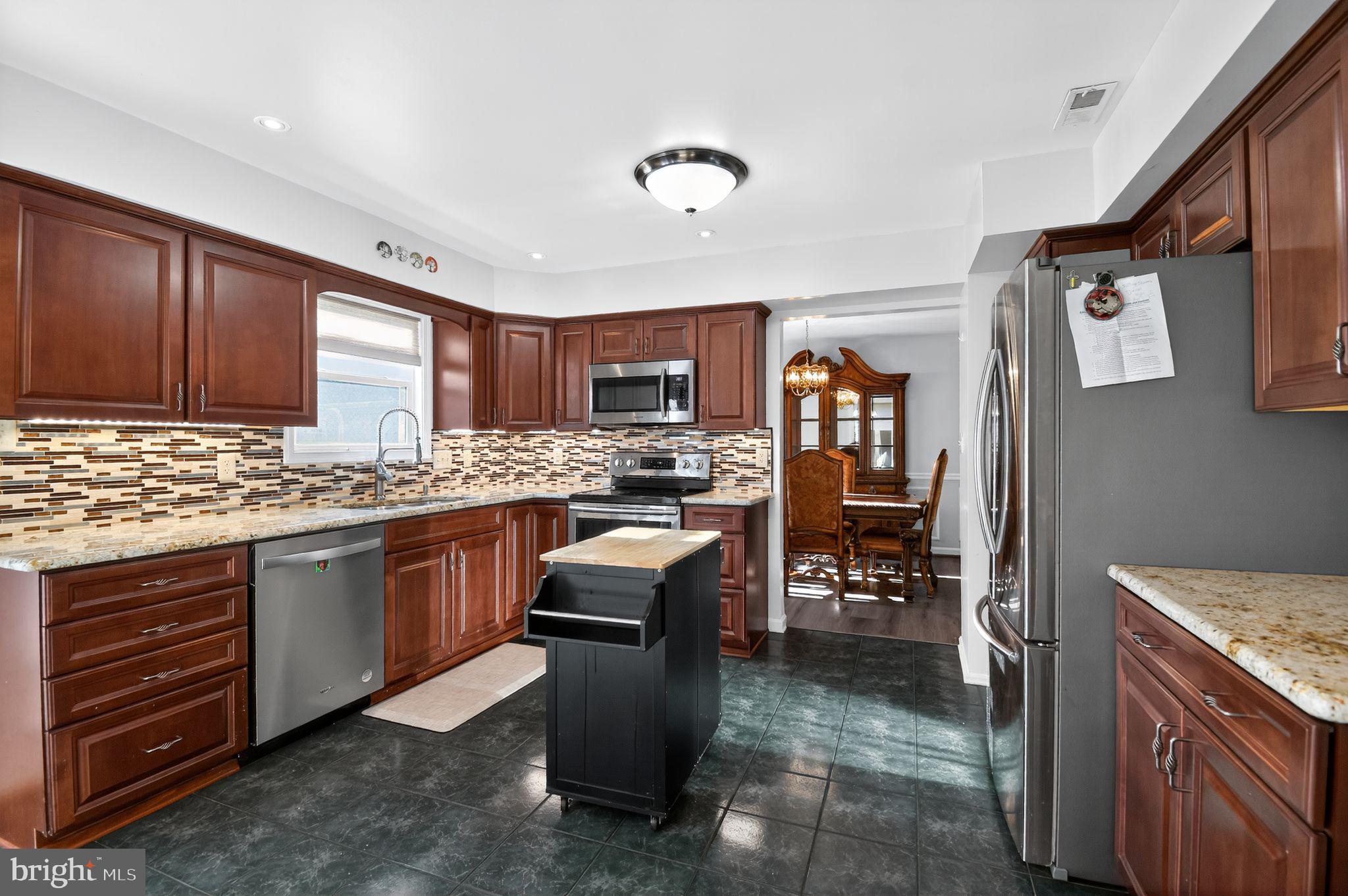 22040 Caravel Court Great Mills, MD 20634 - Photo 7 of 32 a kitchen with granite countertop stainless steel appliances and wooden cabinets
