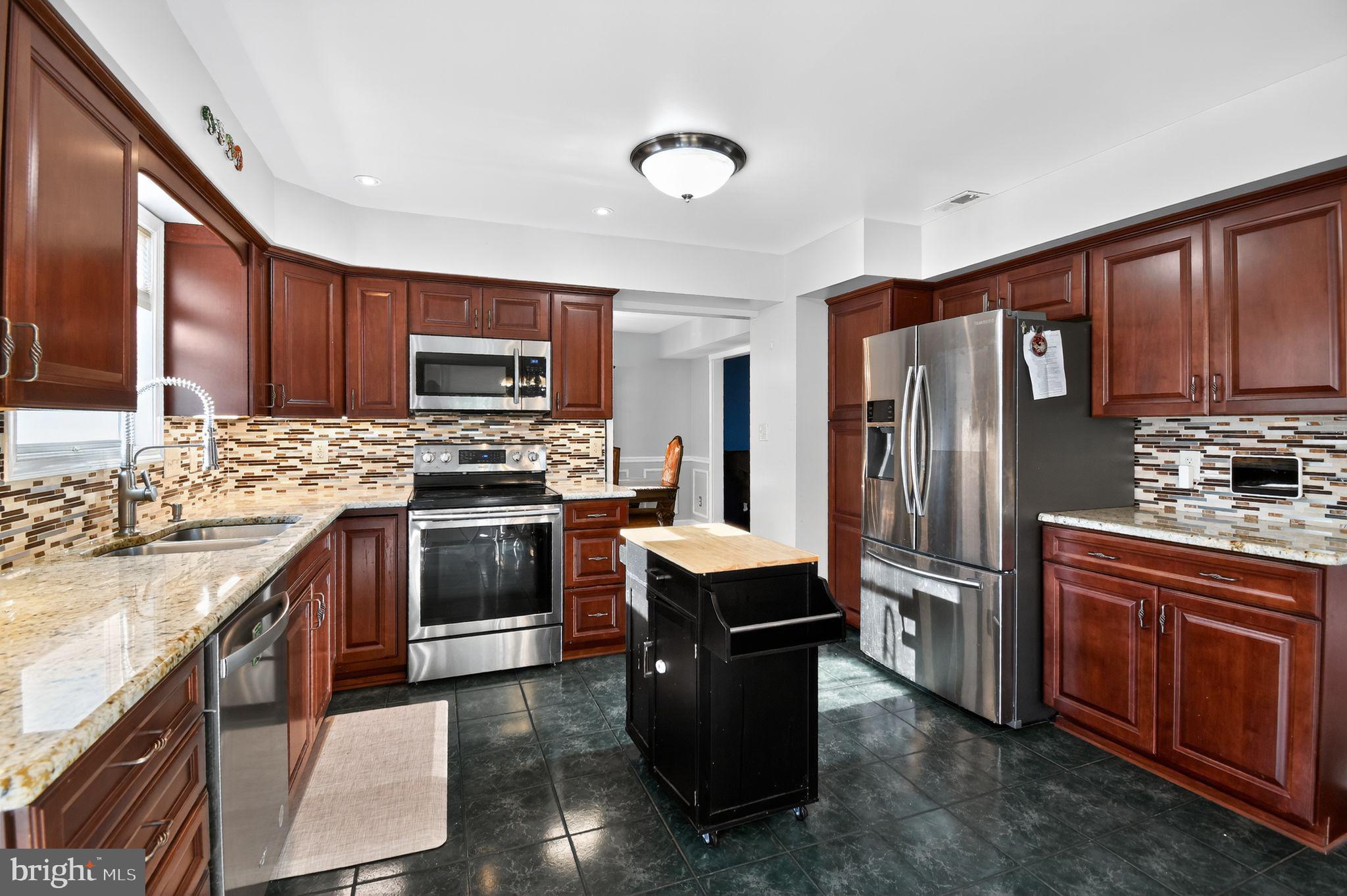 22040 Caravel Court Great Mills, MD 20634 - Photo 10 of 32 a kitchen with granite countertop stainless steel appliances and wooden cabinets