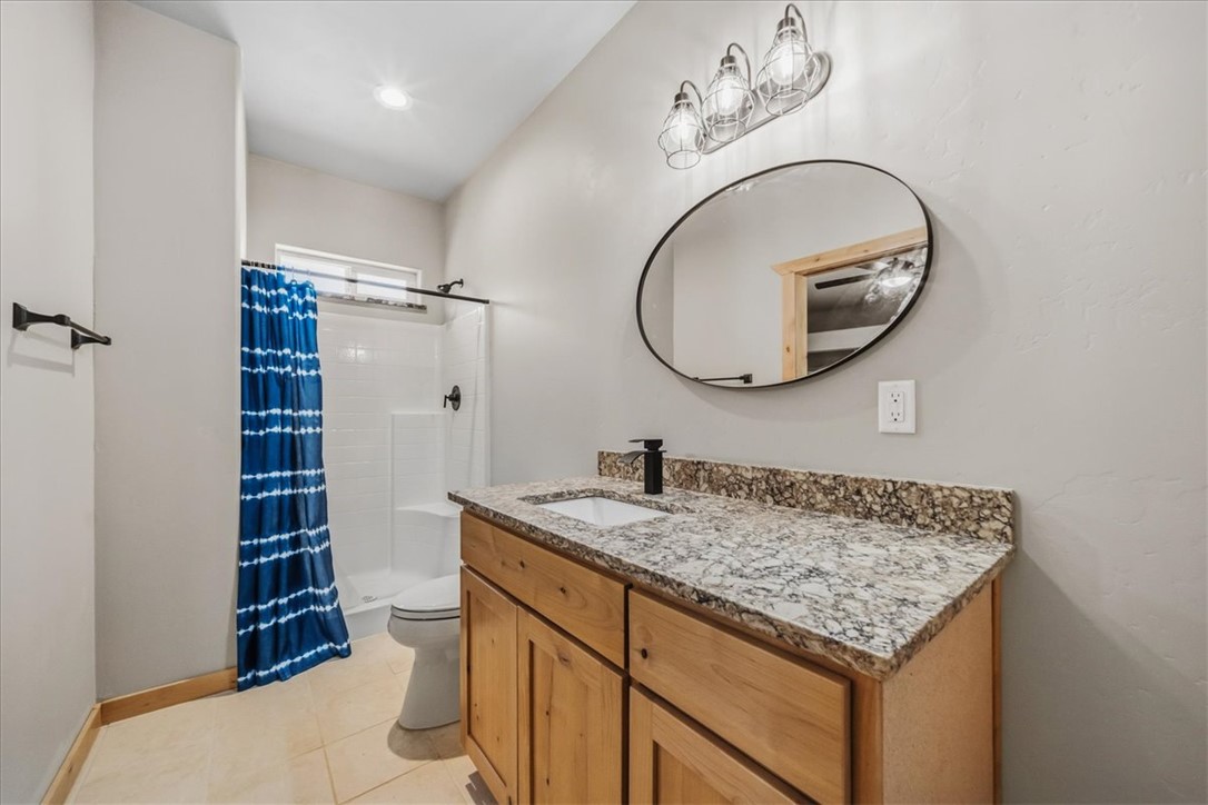 10374 East Happy Trails Road Kingman, AZ 86401 - Photo 30 of 68 a bathroom with a granite countertop sink and a mirror