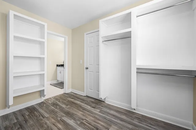 a view of an empty room with cabinet and a window