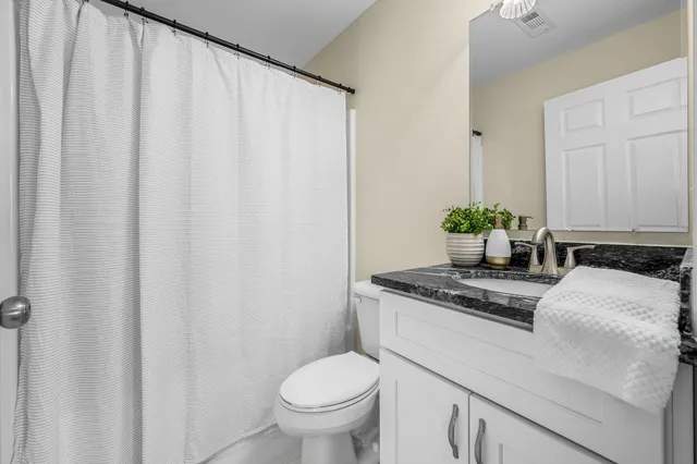 a bathroom with a granite countertop sink and toilet
