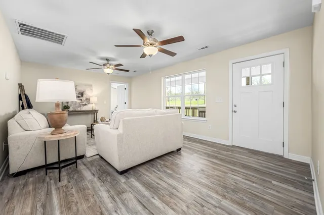 a living room with furniture and a wooden floor