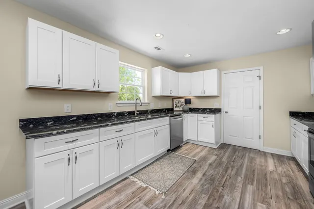 a kitchen with granite countertop white cabinets and white appliances