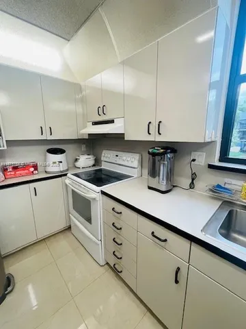 a kitchen with cabinets a sink and appliances