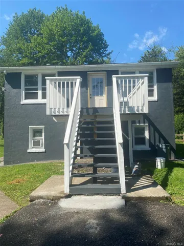 a view of backyard with deck and outdoor seating
