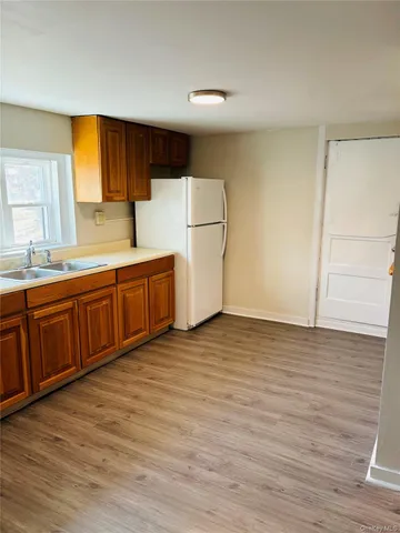 a view of a kitchen with wooden floor and electronic appliances