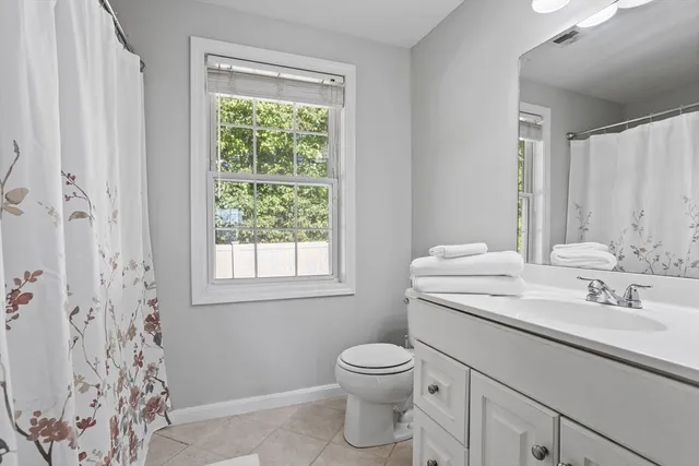 a bathroom with a sink toilet and window