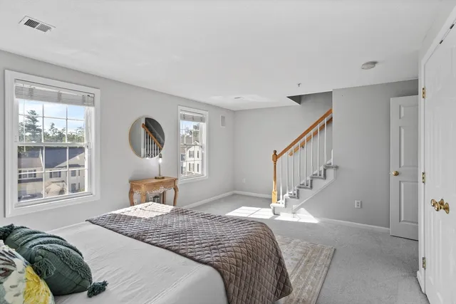 a bedroom with a bed a mirror and a window