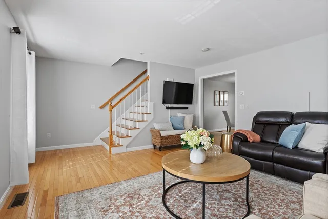 a living room with furniture and wooden floor