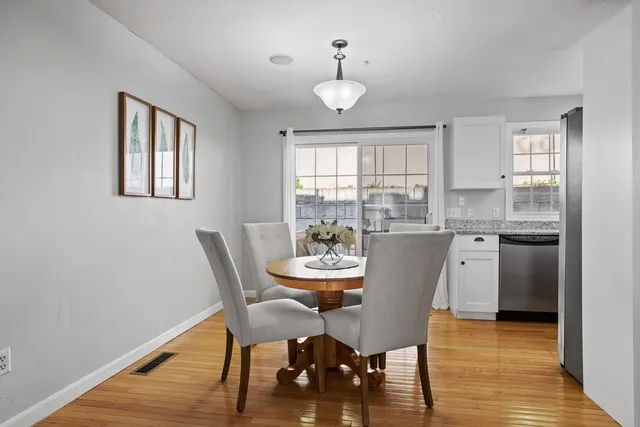 a dining room with furniture a window and wooden floor
