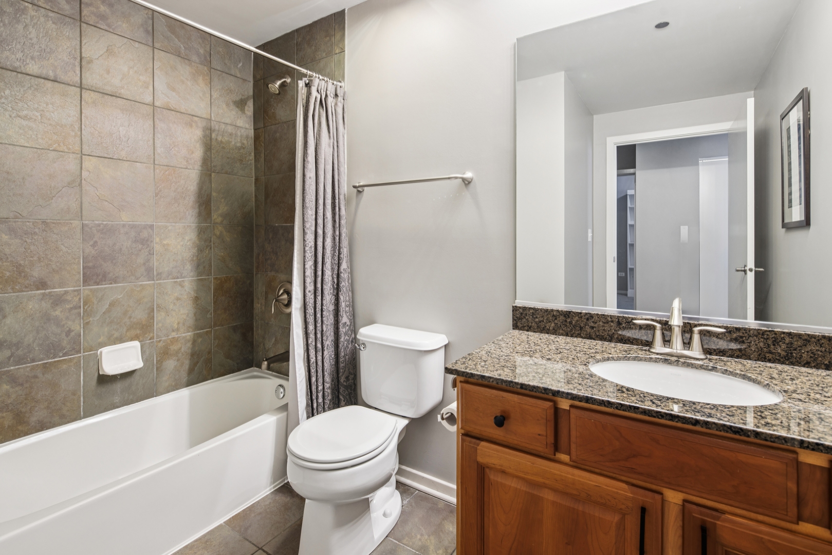 520 South State Street, Unit 816 Chicago, IL 60605 - Photo 12 of 15 a bathroom with a granite countertop sink toilet and shower