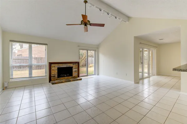 a view of an empty room with a fireplace and a window