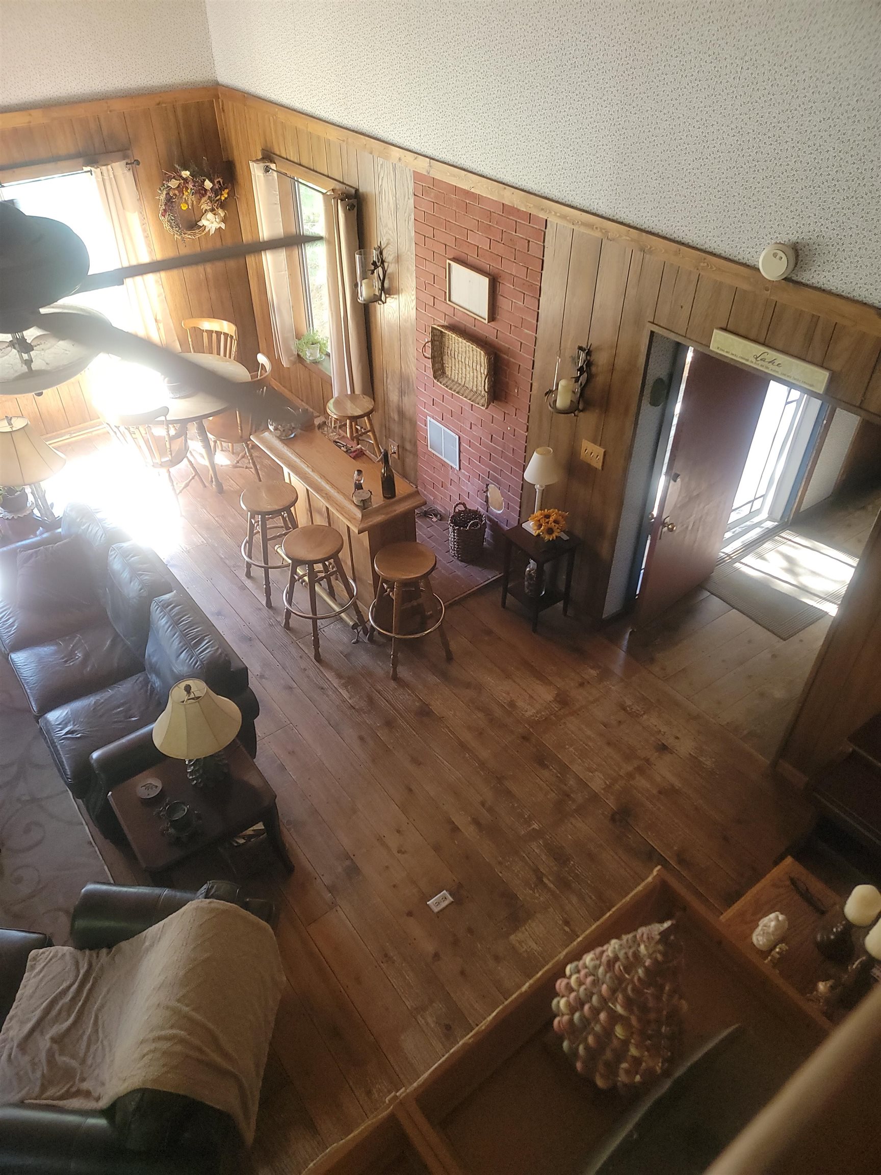 11702 Twin Lakes Road Bridgeport, CA 93517 - Photo 11 of 21 Spacious living area featuring wood-finish flooring, paneled walls, and a prominent brick-clad accent wall