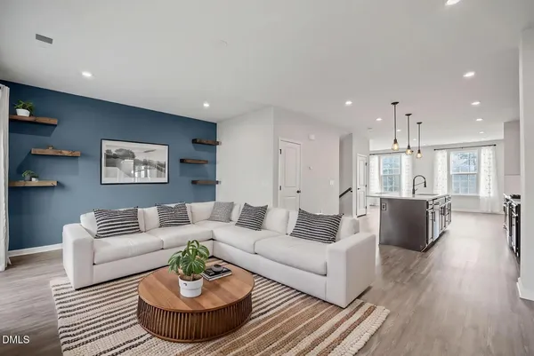 a kitchen with stainless steel appliances granite countertop wooden cabinets a sink dishwasher a stove and a refrigerator with wooden floor