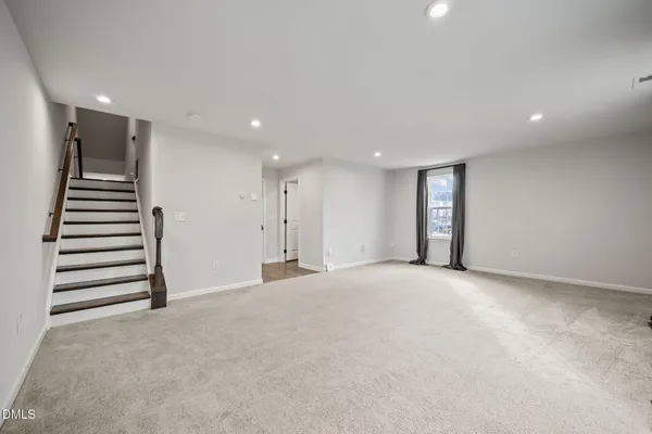 an empty room with windows and chandelier fan